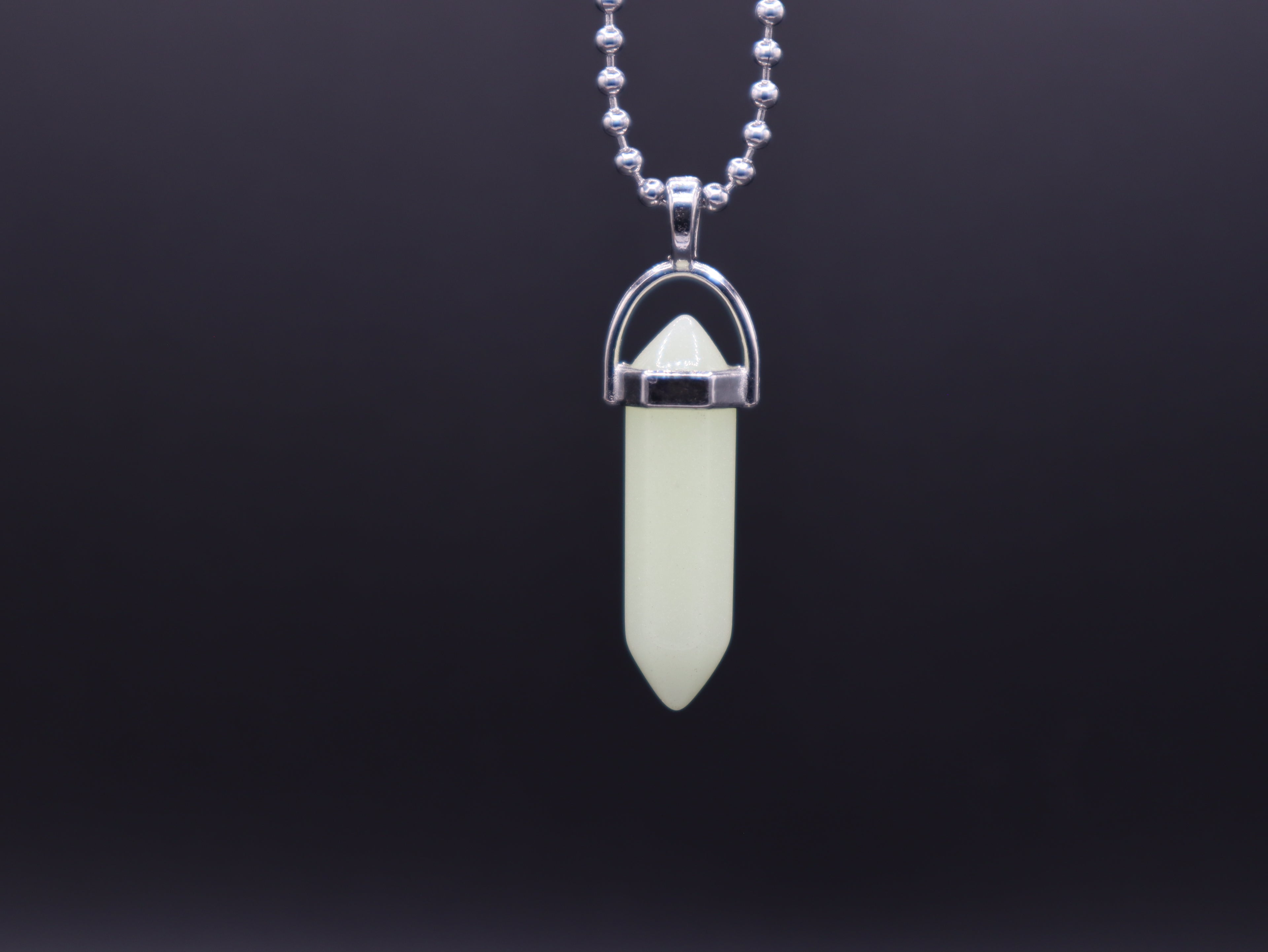 Necklace with a green crystal pendant on a black background