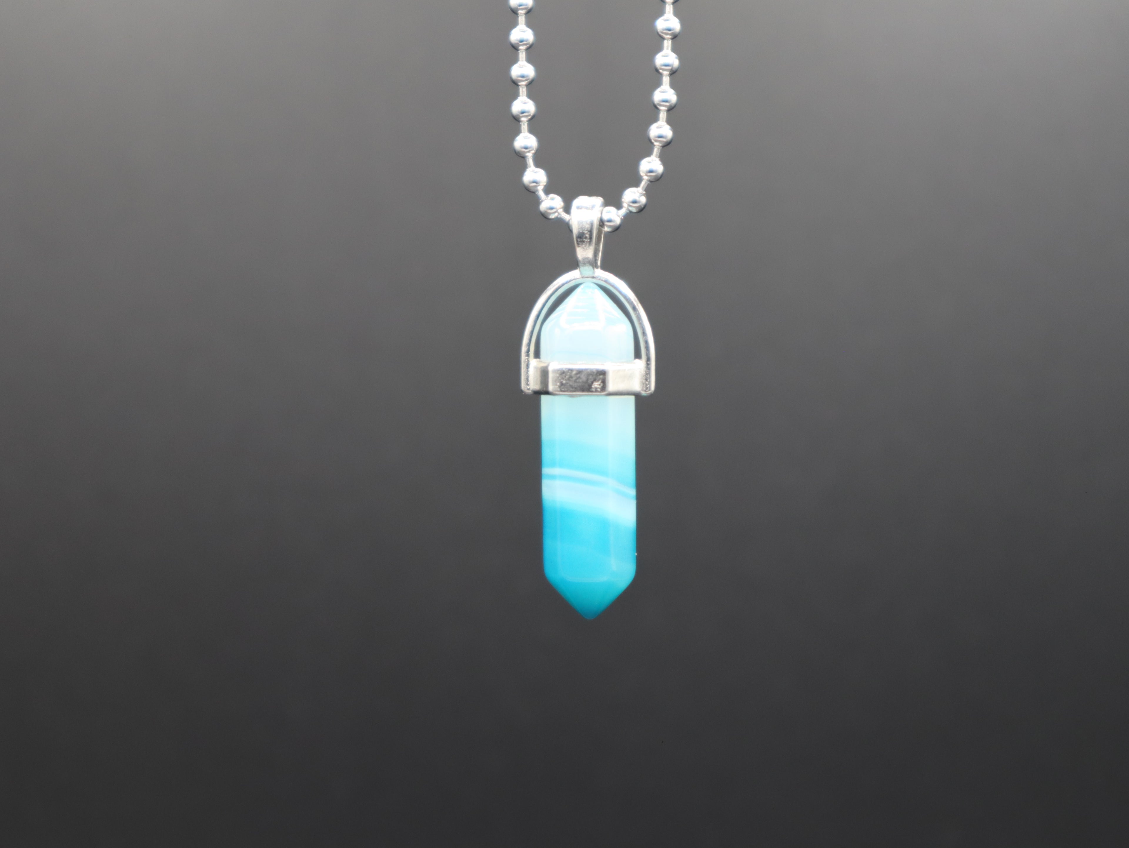 Turquoise pendant necklace on a dark background