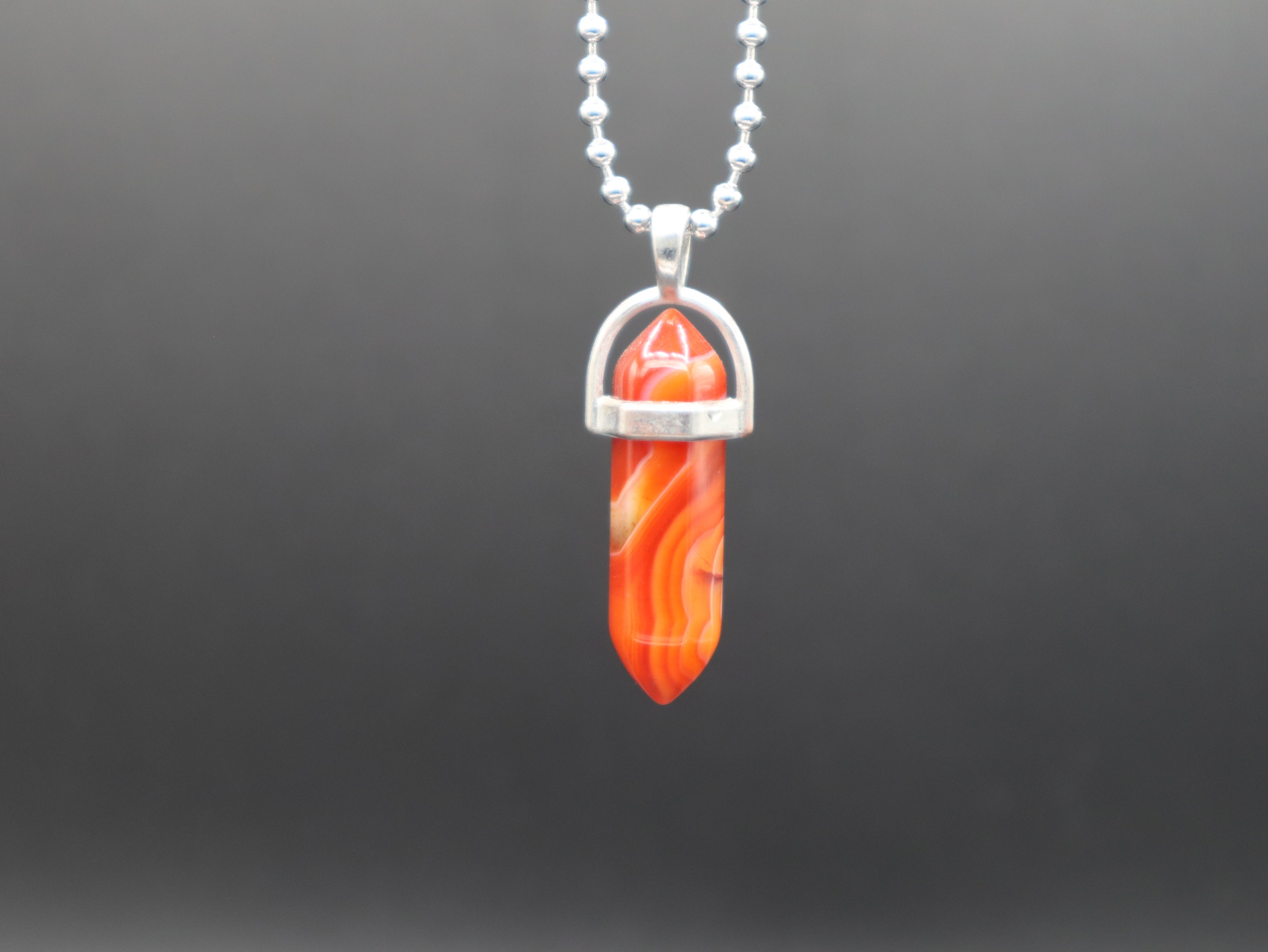 Necklace with a red stone pendant on a gray background