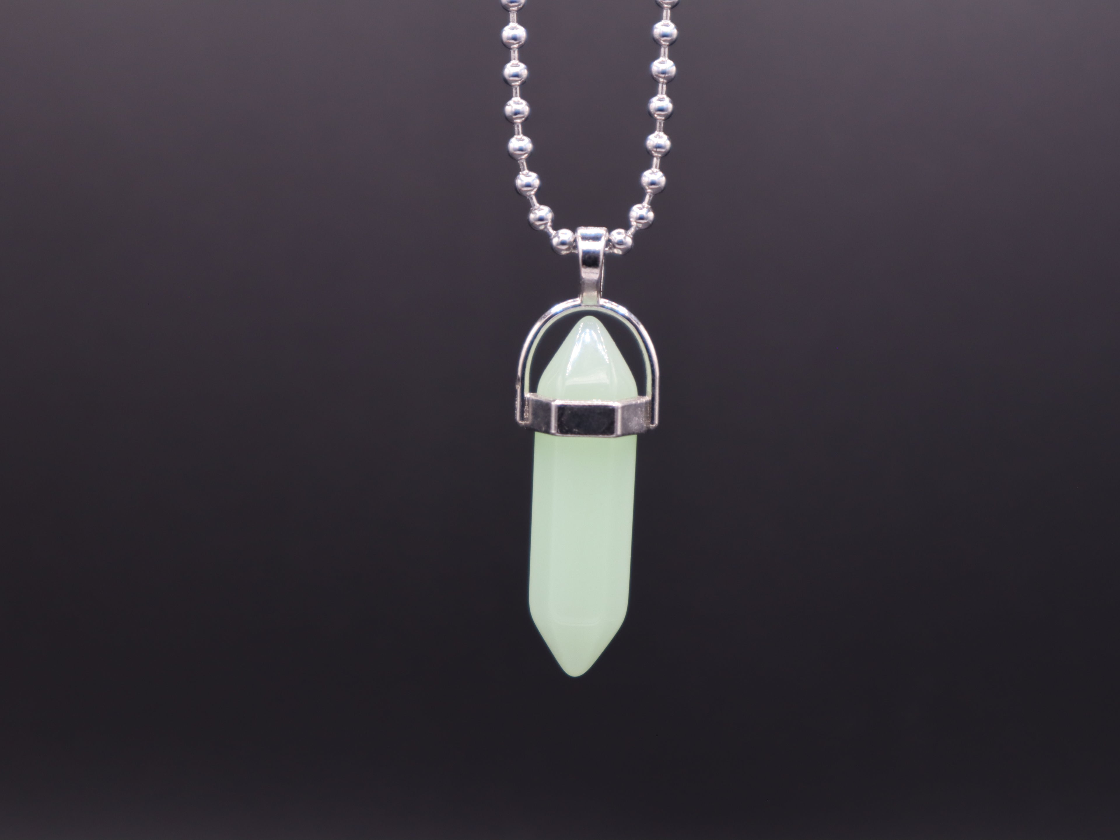 Necklace with a green crystal pendant on a black background
