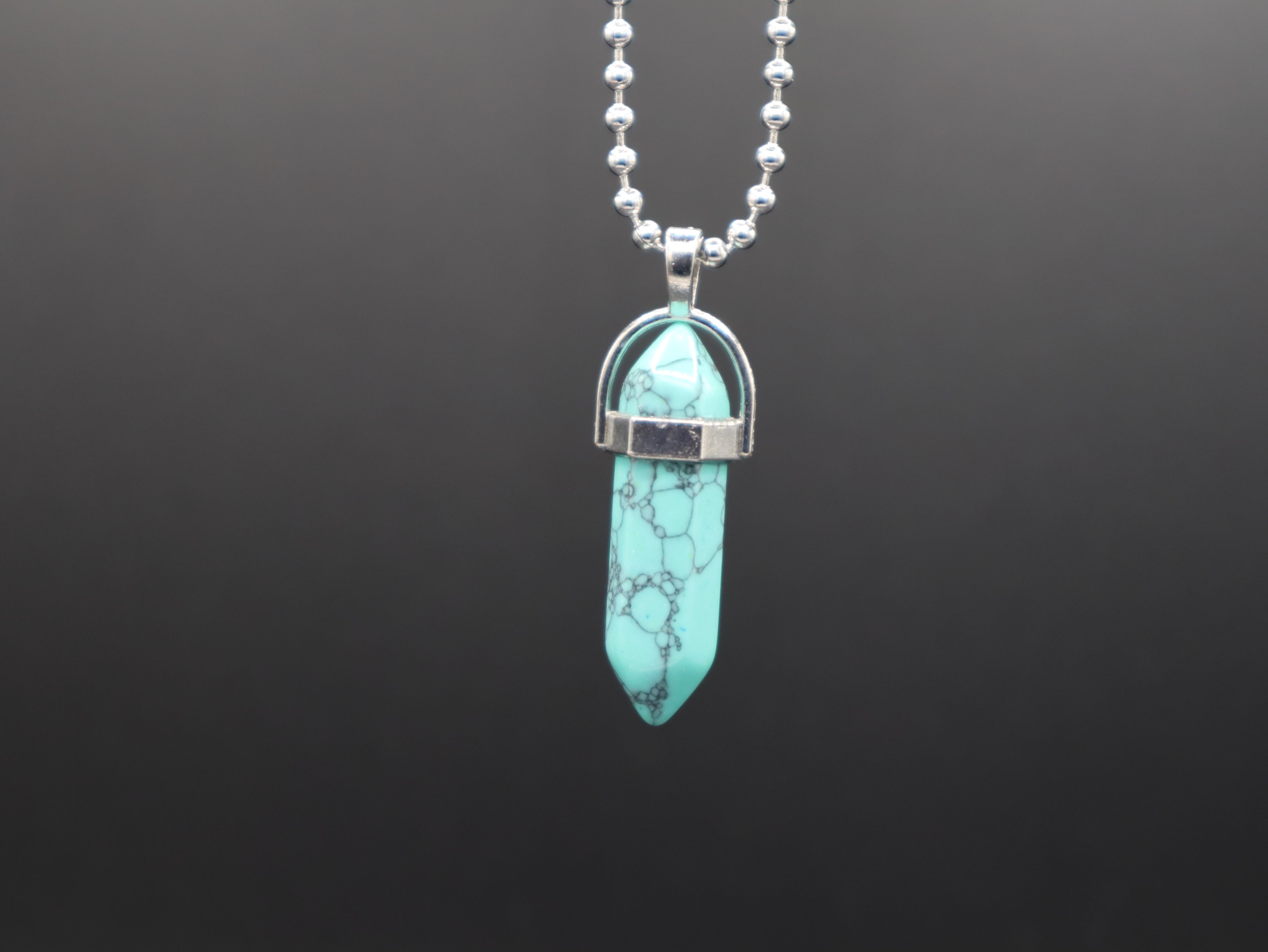 Turquoise pendant necklace on a black background
