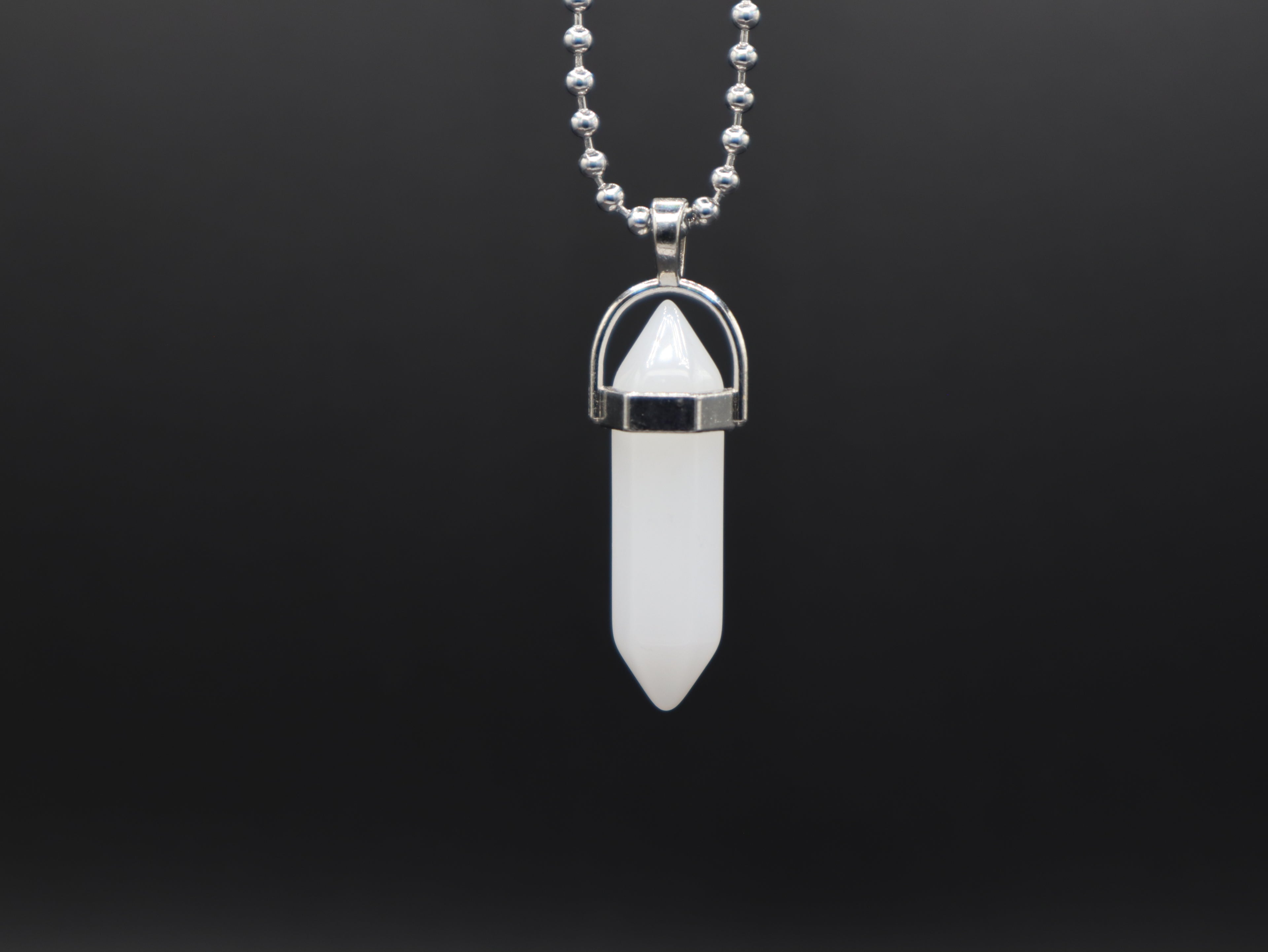 Necklace with a white crystal pendant on a black background