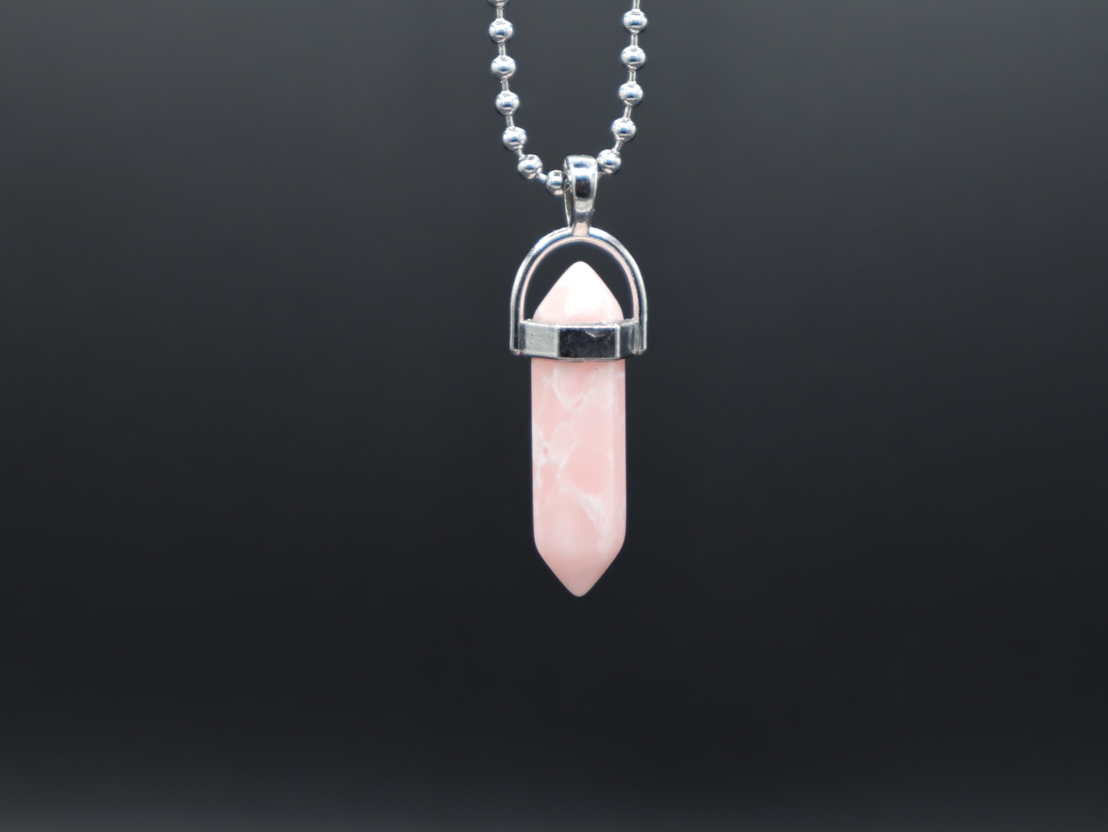 Pink crystal pendant necklace on a black background