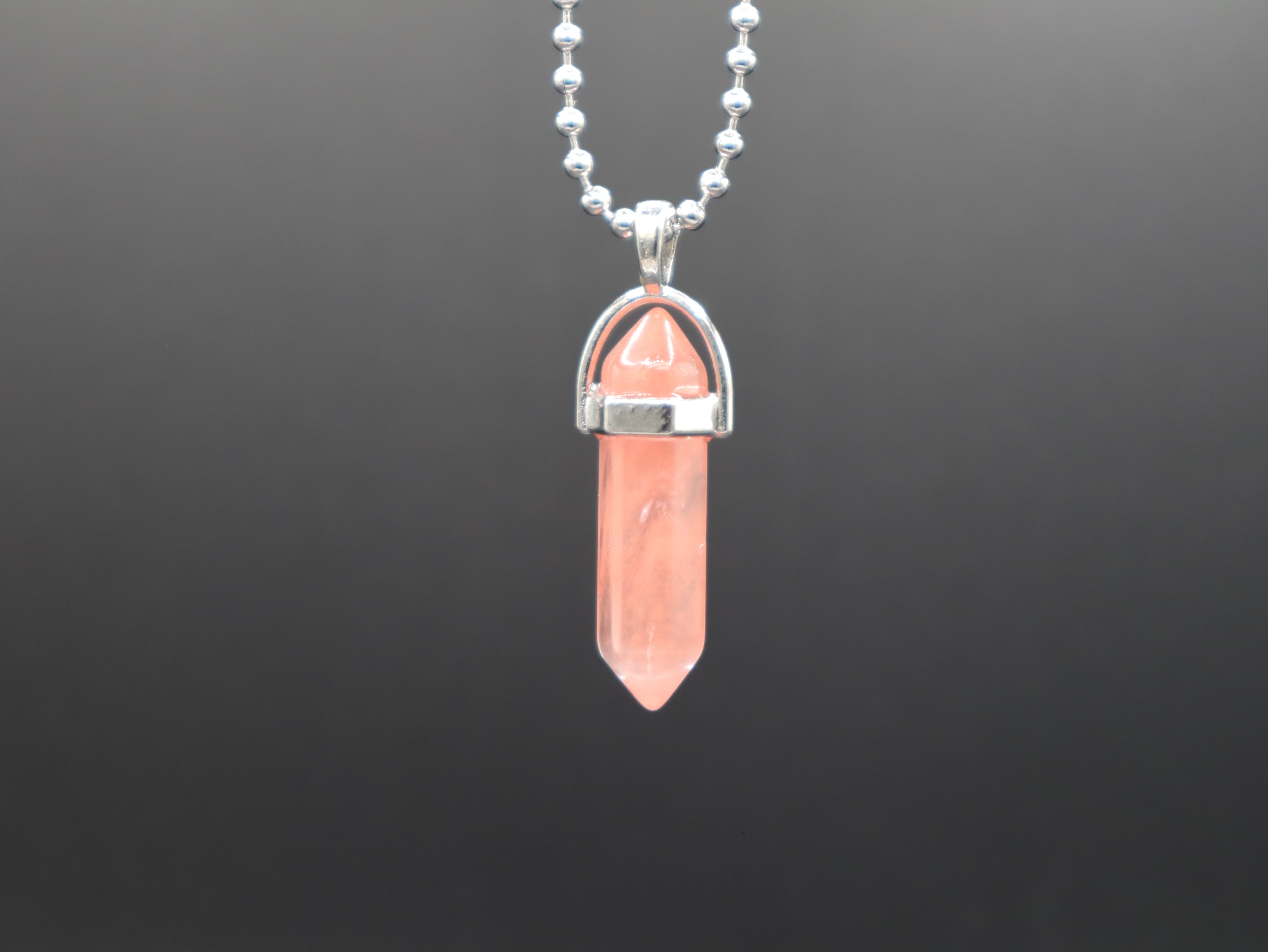 Necklace with a pink crystal pendant on a dark background