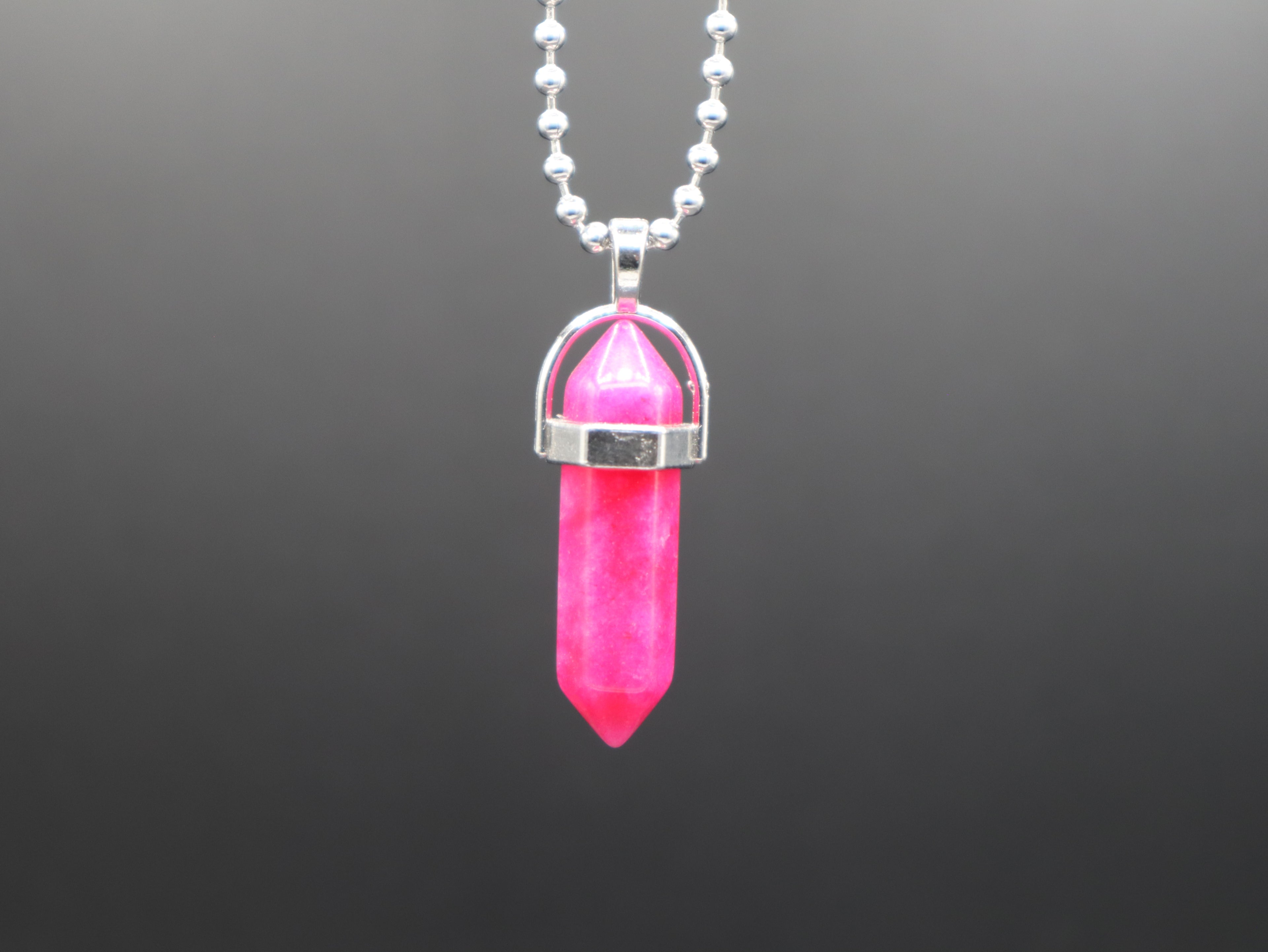 Pink crystal pendant necklace on a dark gray background