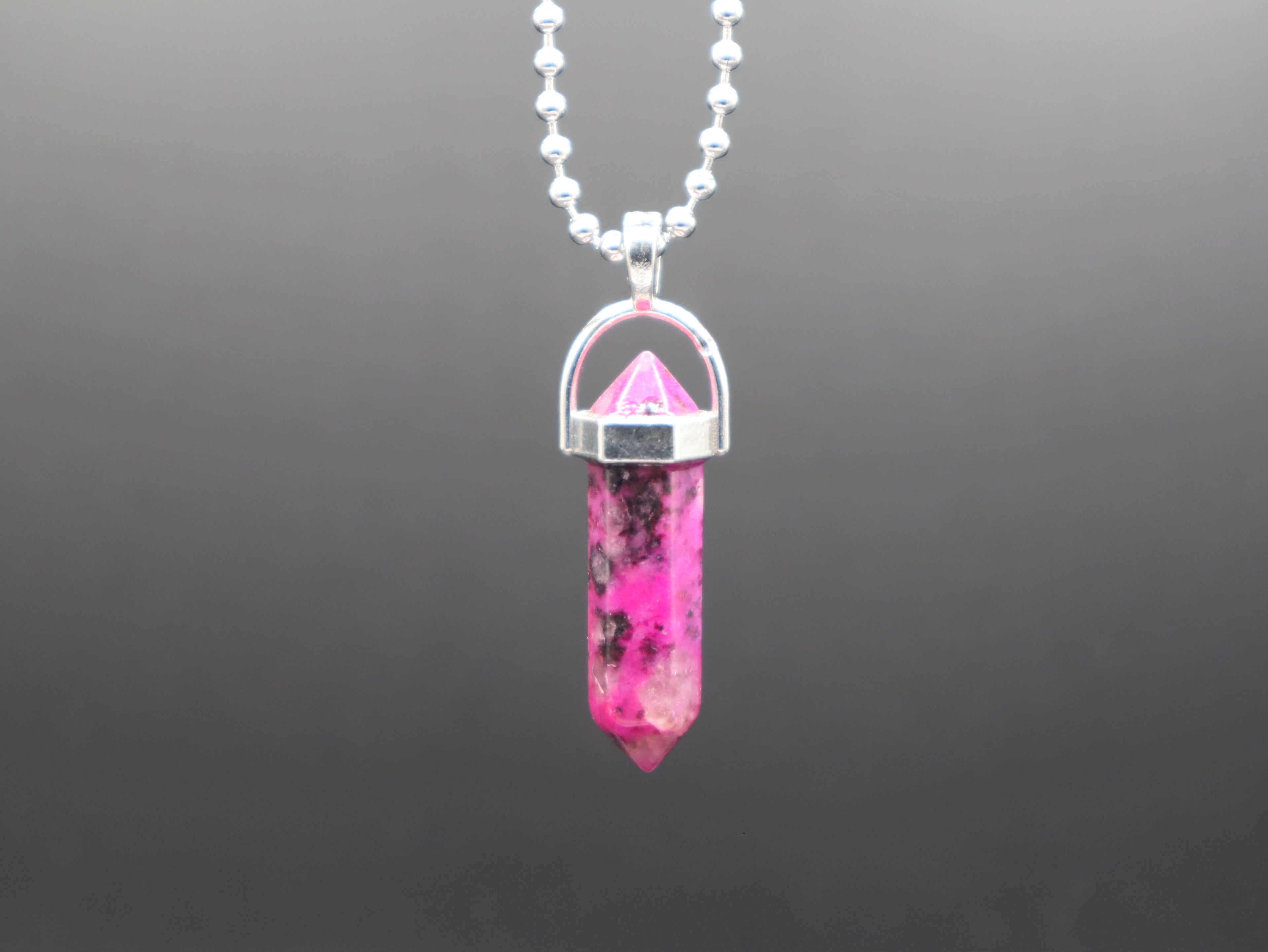 Necklace with a pink crystal pendant on a gray background