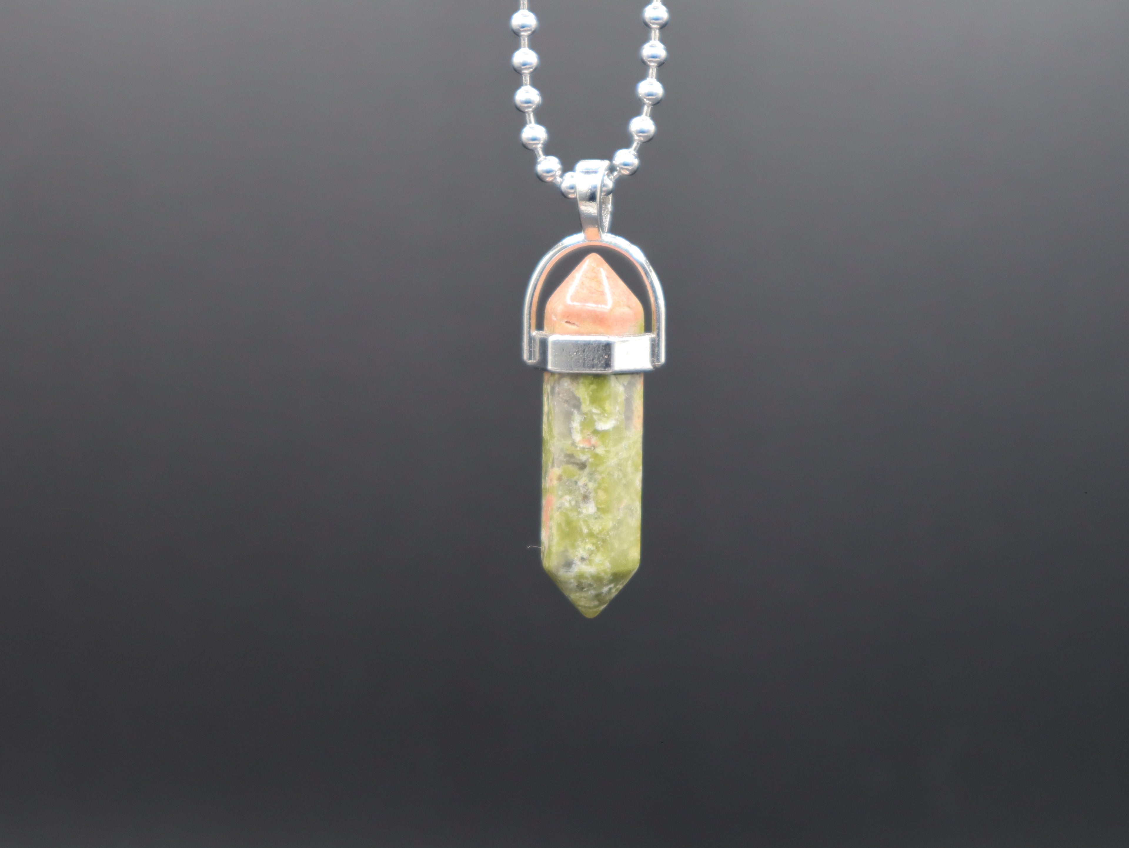 Crystal pendant necklace on a dark gray background