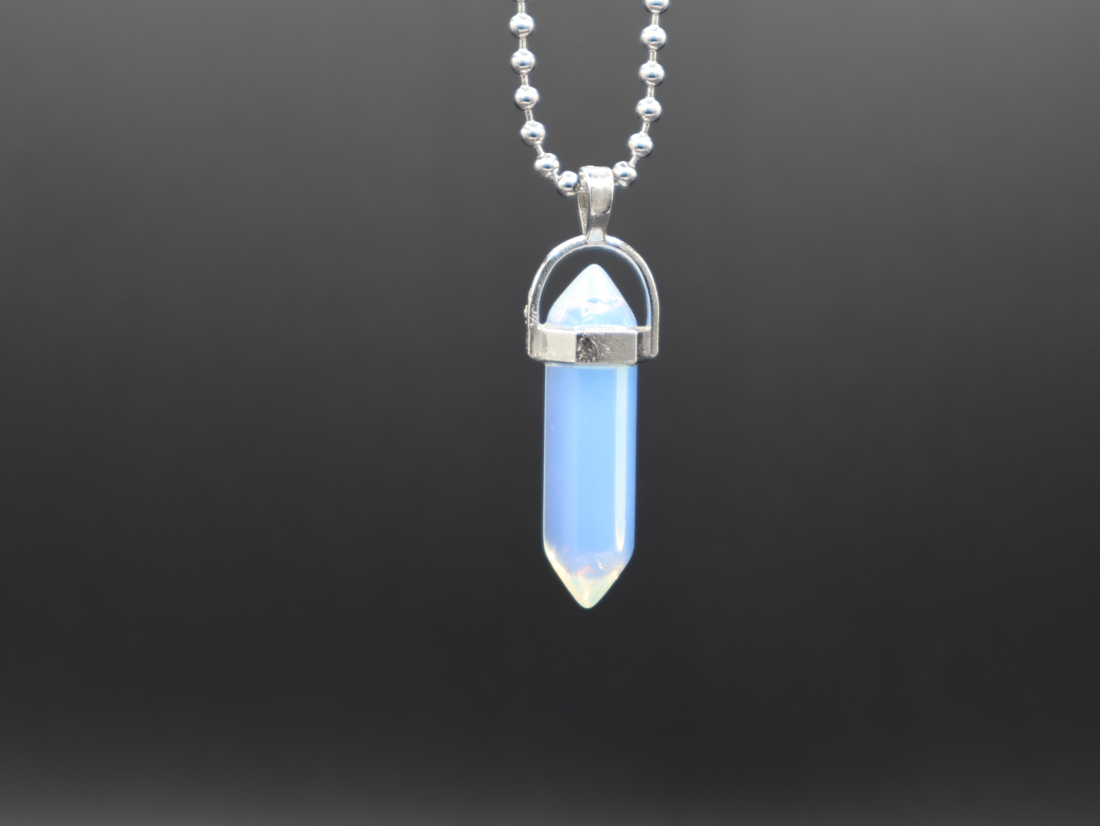 Blue crystal pendant necklace on a dark background